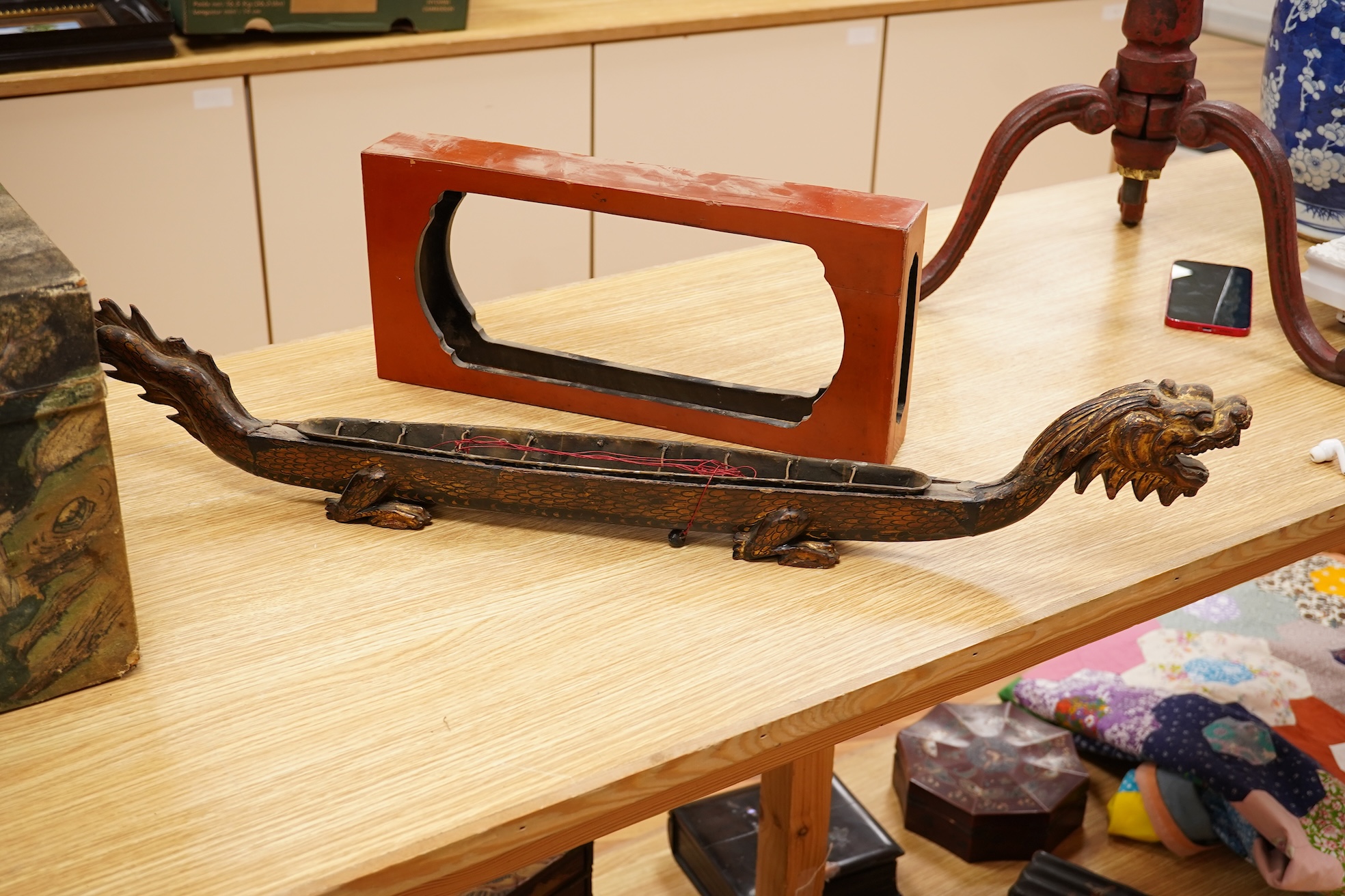 A South East Asian gilt decorated black lacquer model 'dragon' boat on stand, 75cm